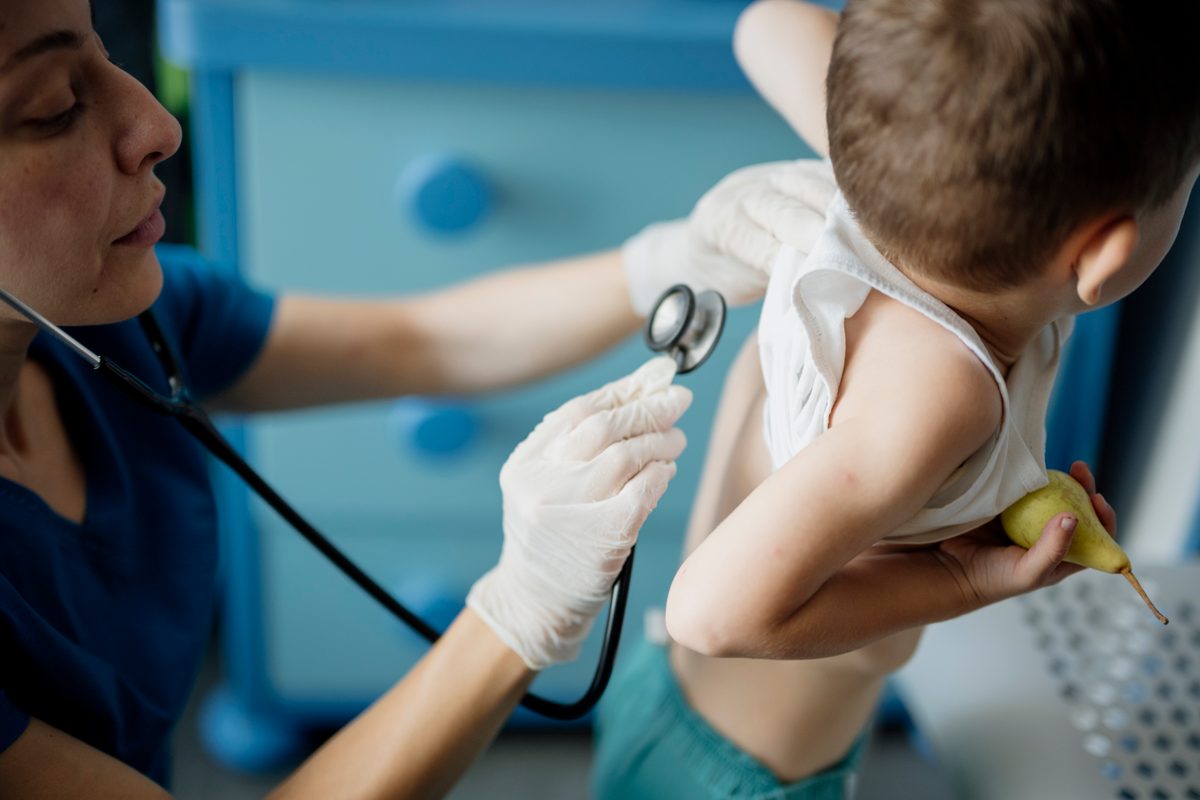 A doctor listens to a child's chest with a stethoscope during a checkup