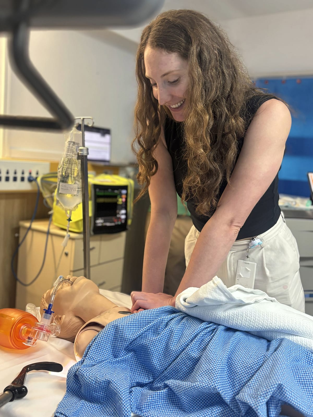 A registrar practising chest compressions on a resuscitation training manikin