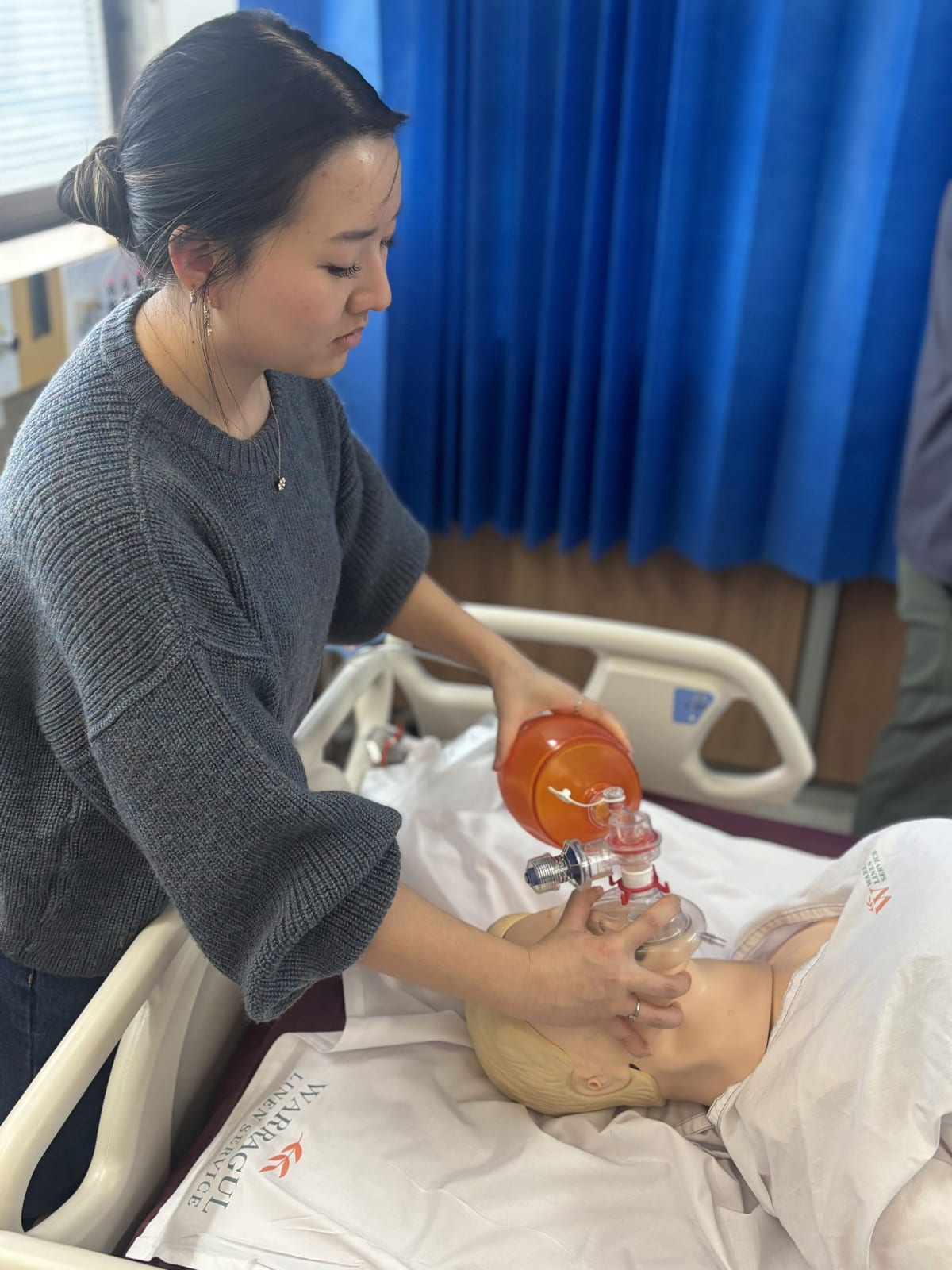 A registrar practising bag-valve-mask ventilation on an airway training manikin